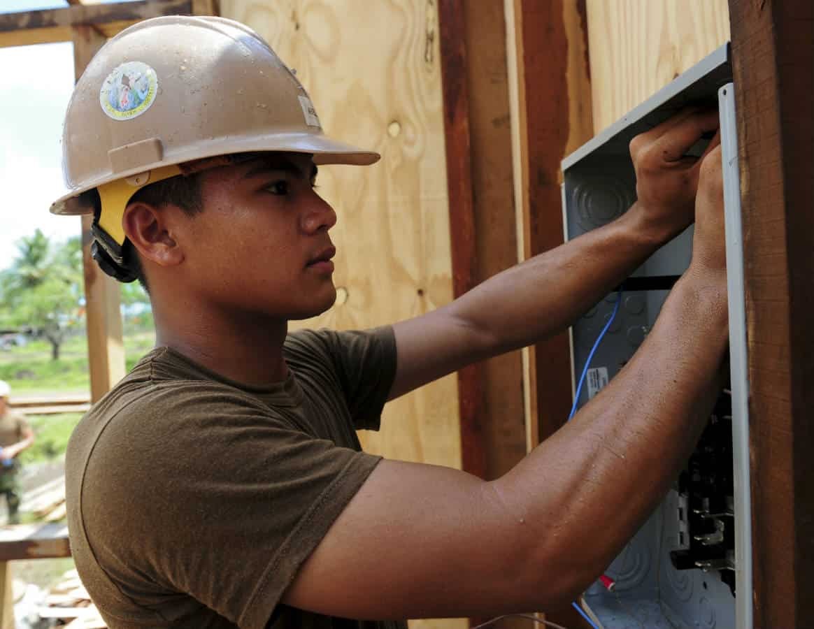 Man working on electrical box in Guyana